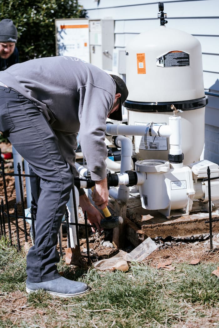 pool repair technician fixing broken pool equipment