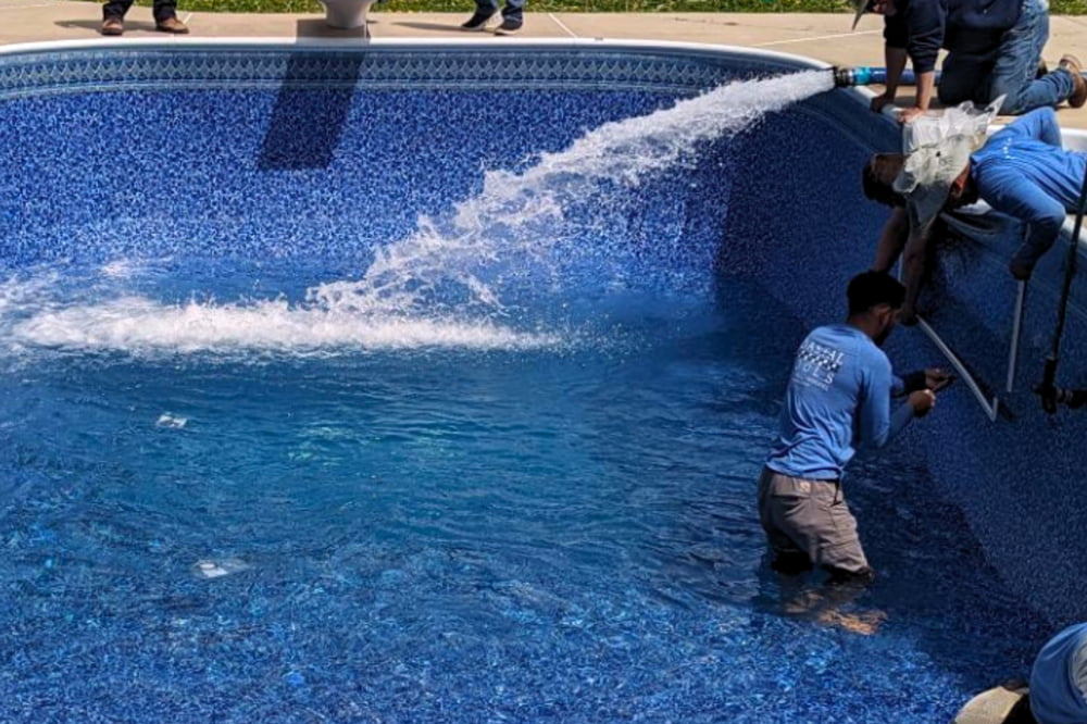 workers replacing an in-ground vinyl pool