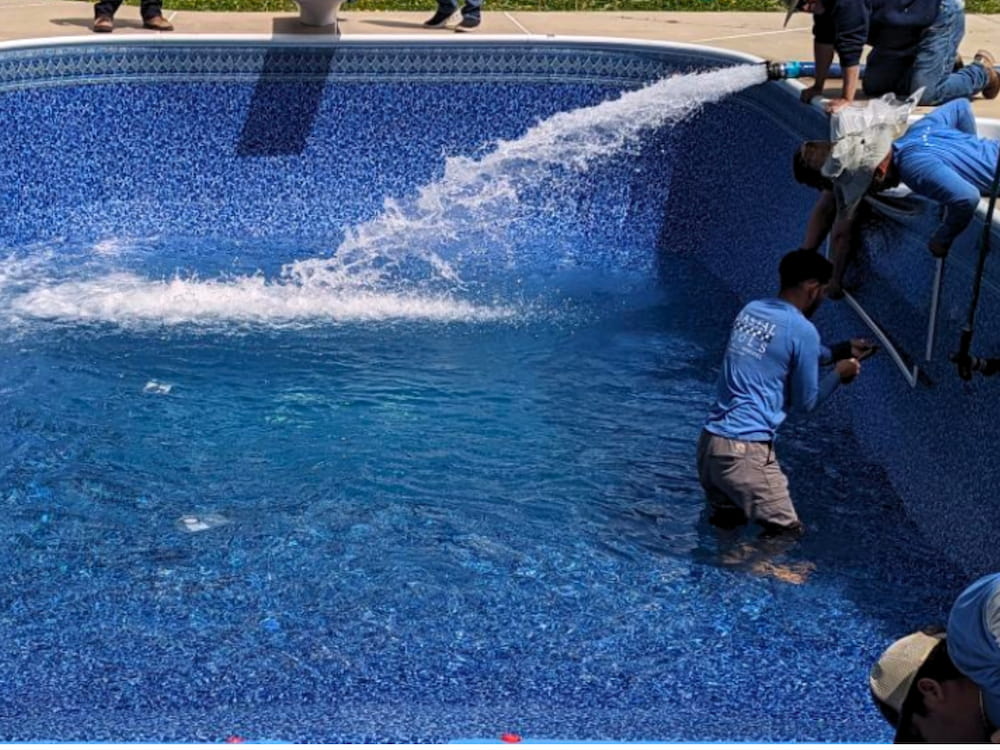 workers replacing an in-ground vinyl pool
