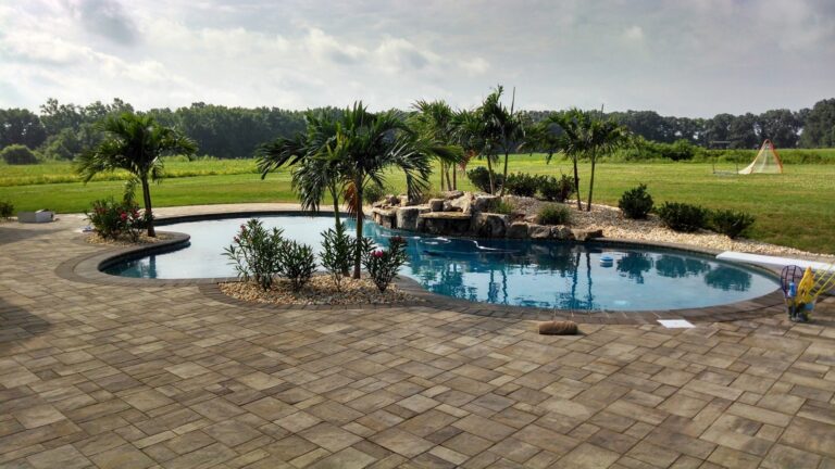 a free form pool with a custom waterfall, patio, and tanning shelf in Centreville, MD