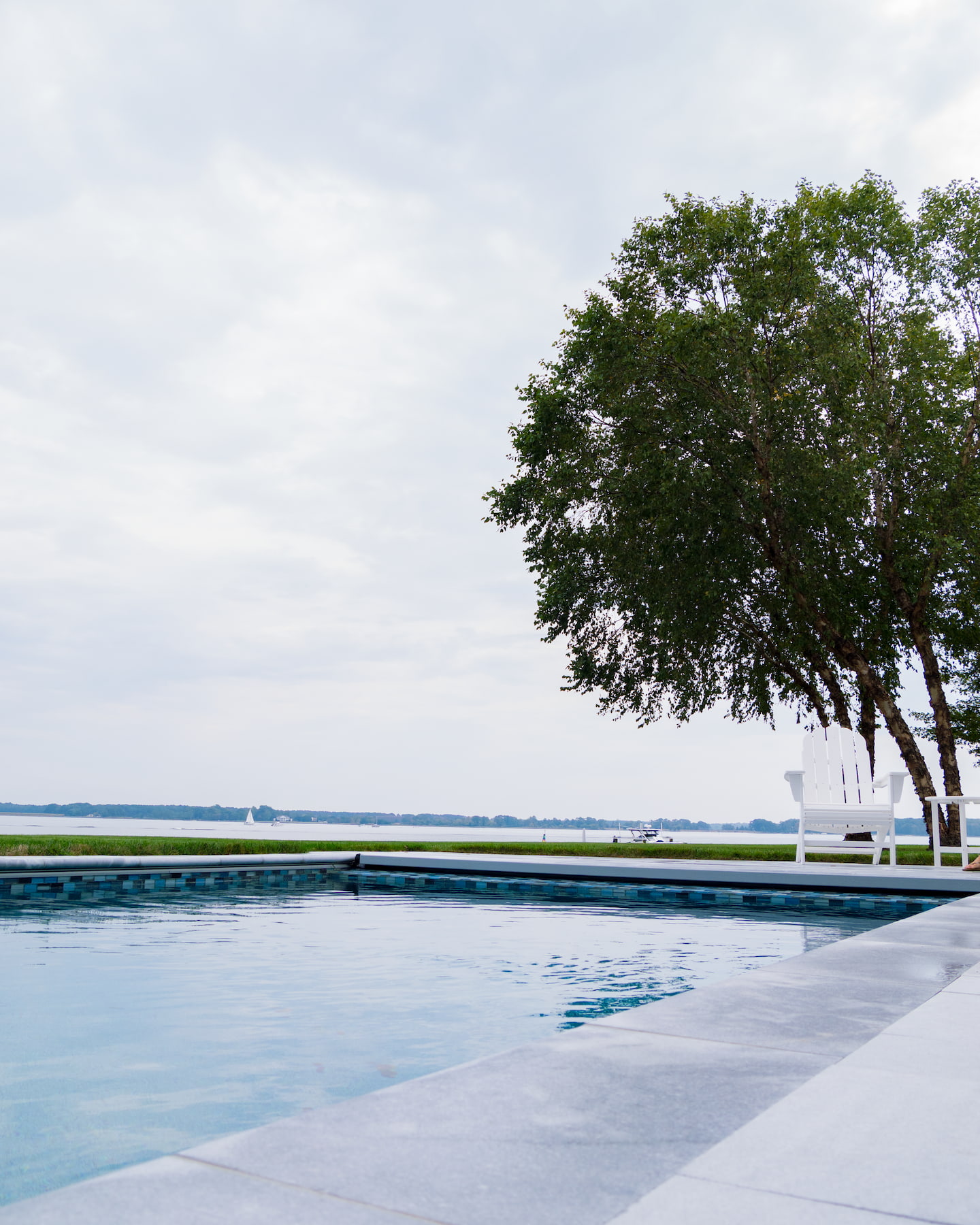 geometric in-ground pool with coastline in the background