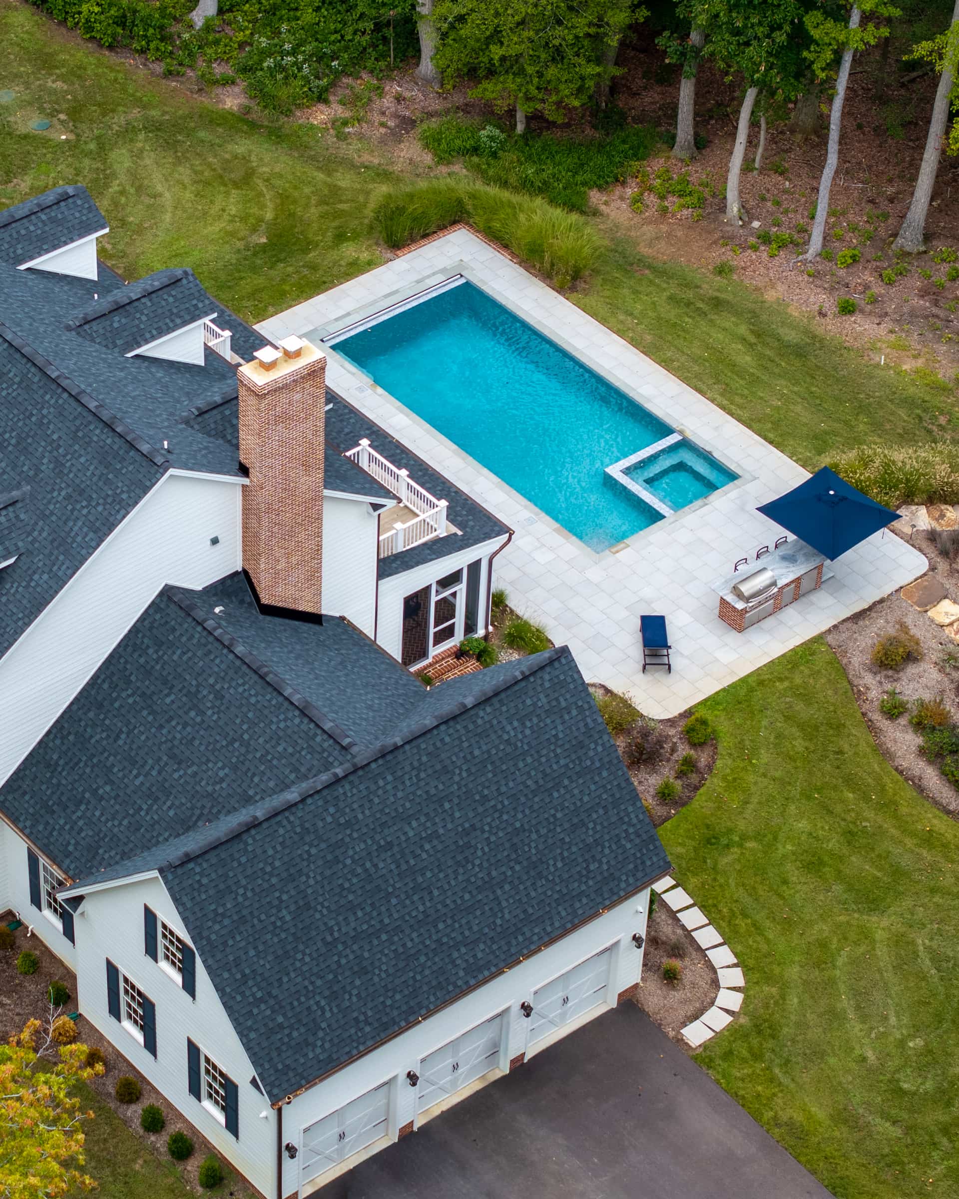 aerial view of geometric pool and spa and outdoor kitchen