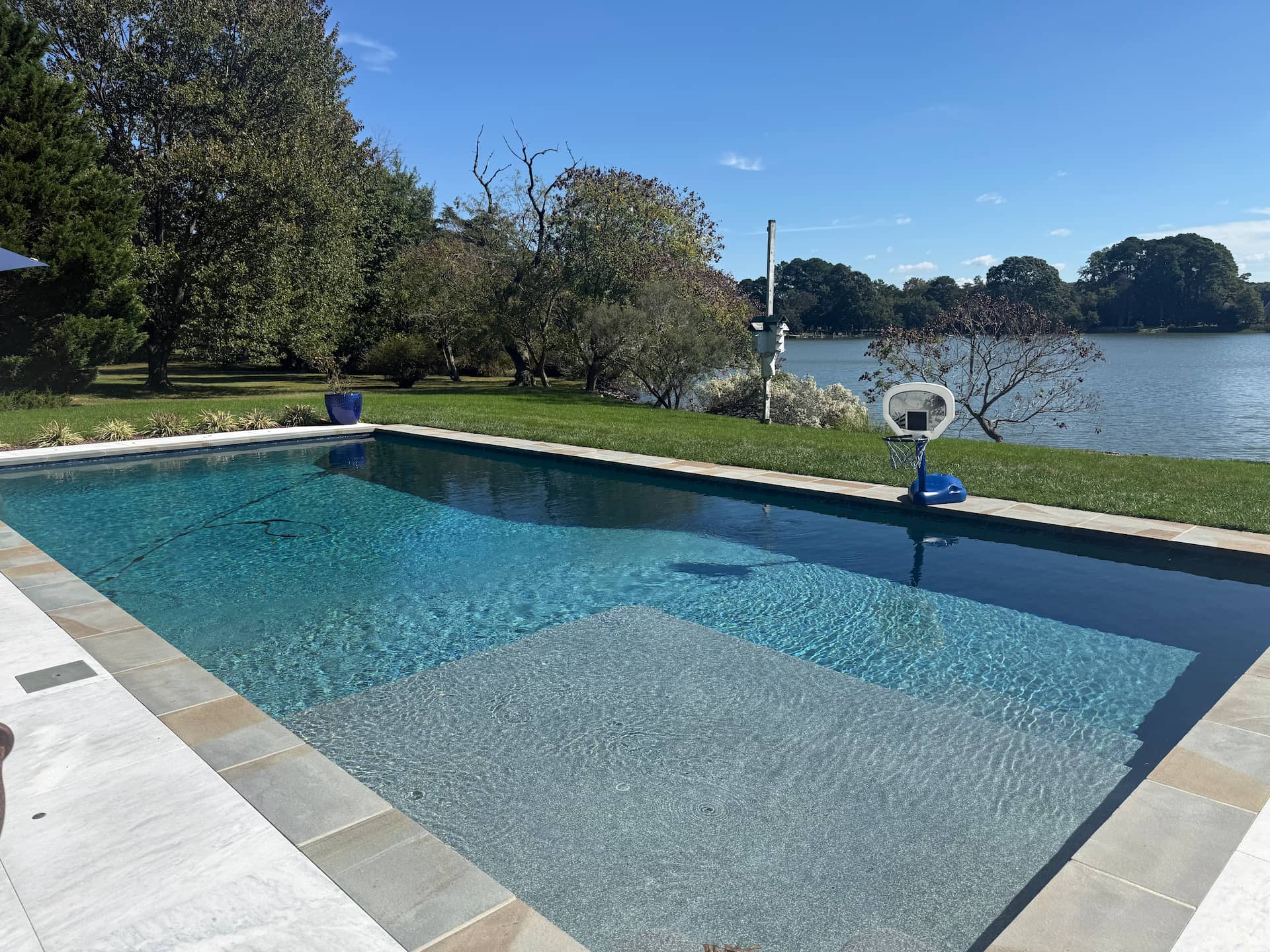 geometric pool near cost with basketball hoop on pool edge