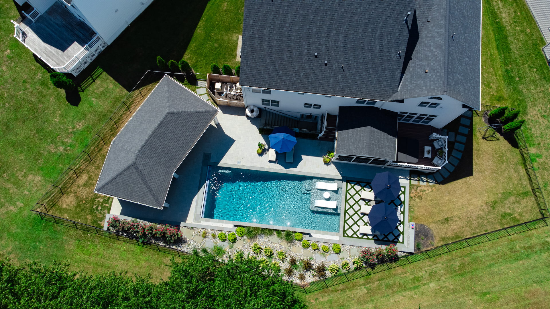 aerial view of backyard showing pool, pool house, and landscaping